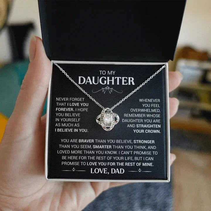 The necklace in its black gift box, held in a hand to show its size